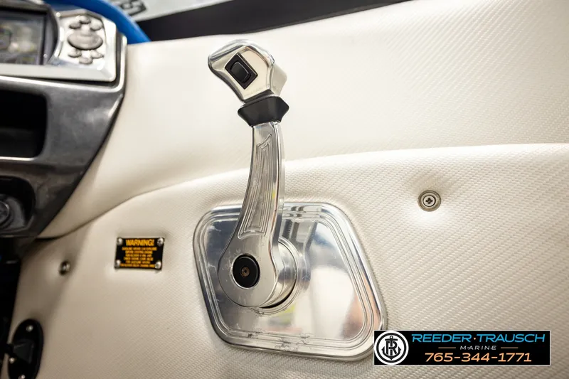 Slide: The Image of 2013 Tigé RZR boat throttle control lever with warning label and contact information. - 36