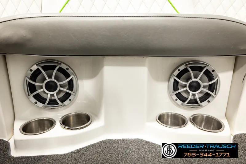 Slide: The Image of 2013 Tigé RZR boat interior with speakers and cup holders, featuring Reeder Trausch Marine branding. - 44