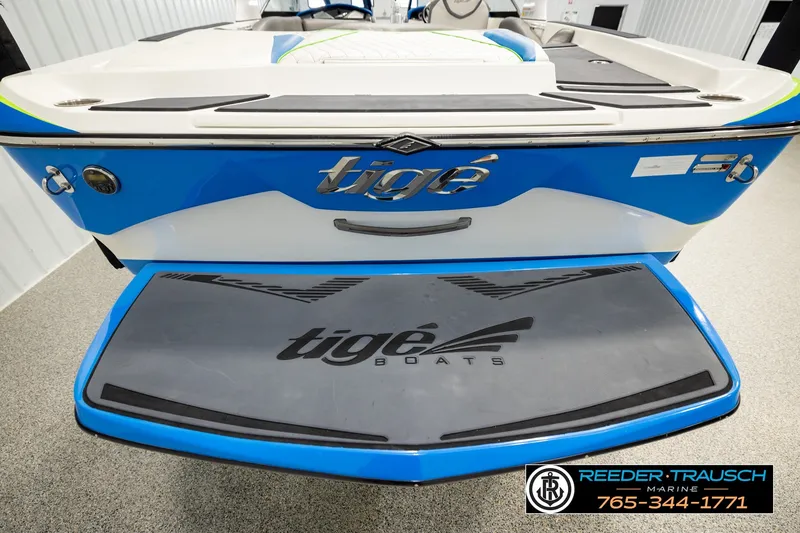 Slide: The Image of 2013 Tigé RZR boat rear view with blue and white design in showroom. - 49