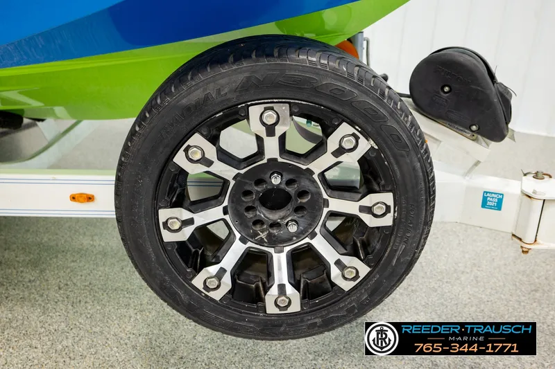 Slide: The Image of 2013 Tigé RZR boat trailer wheel with stylish black and silver rim design. - 53