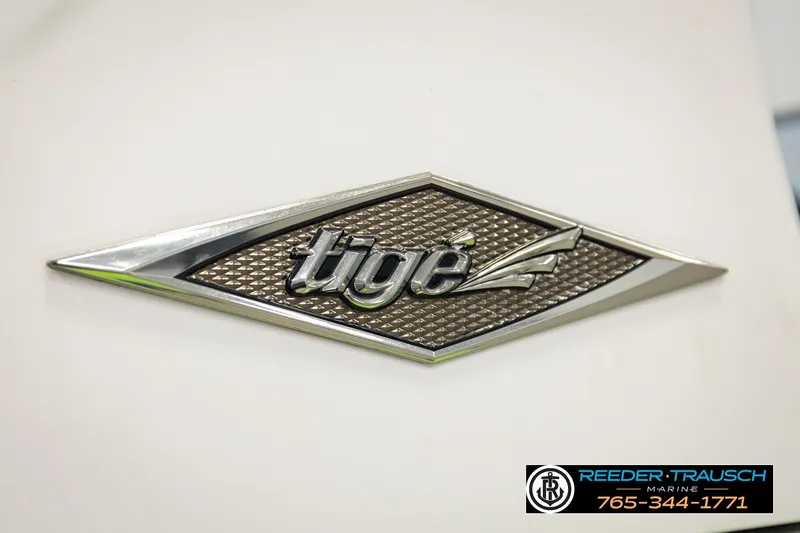Slide: The Image of 2013 Tigé RZR logo on a textured metallic background. - 54