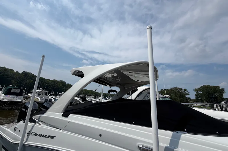 Slide: The Image of 2021 Crownline Eclipse E305 XS boat docked under a cloudy sky. - 4
