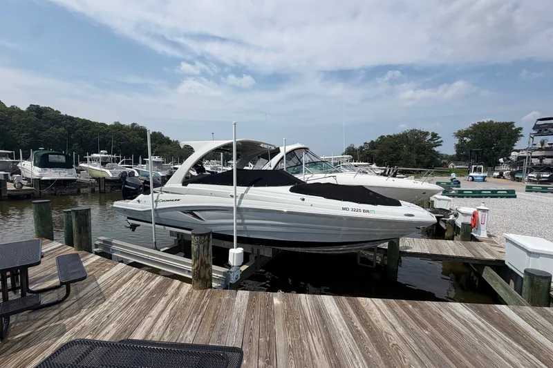 The Image of 2021 Crownline Eclipse E305 XS boat docked at a marina under a cloudy sky. - 0