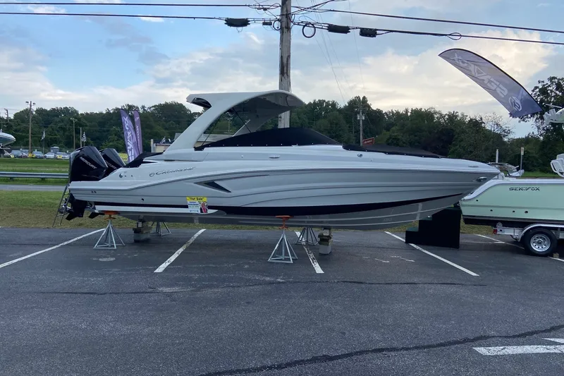 Slide: The Image of 2021 Crownline Eclipse E305 XS boat displayed on stands in a parking lot. - 5