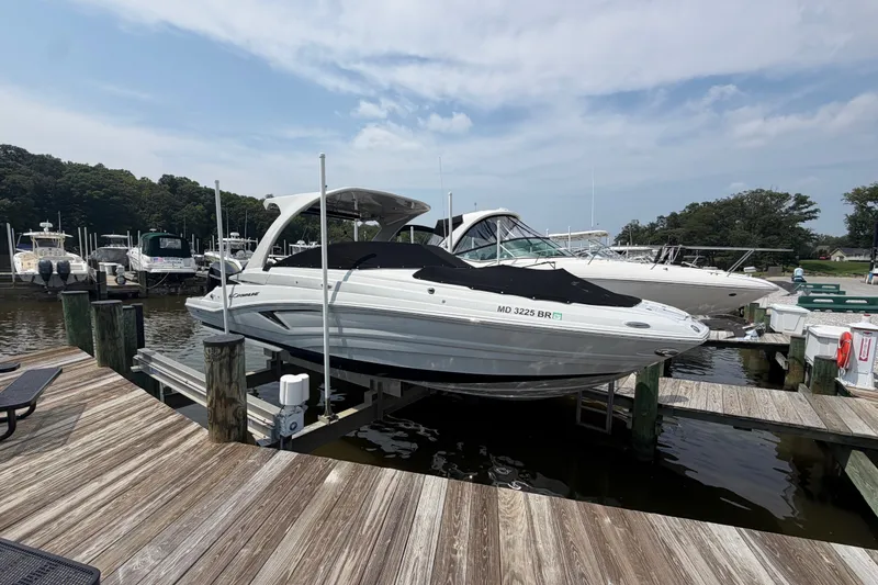 Slide: The Image of 2021 Crownline Eclipse E305 XS boat docked at a marina under a cloudy sky. - 1