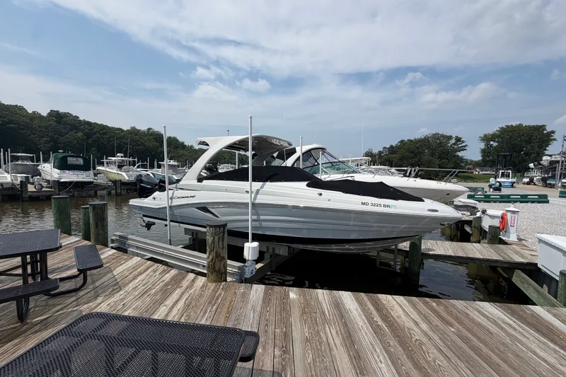Slide: The Image of 2021 Crownline Eclipse E305 XS boat docked at marina under cloudy sky. - 2