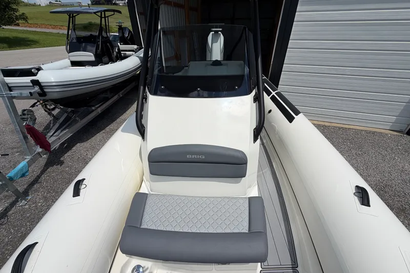 Slide: The Image of 2027 Brig Eagle 8 boat with sleek design, parked on a trailer near a garage. - 27