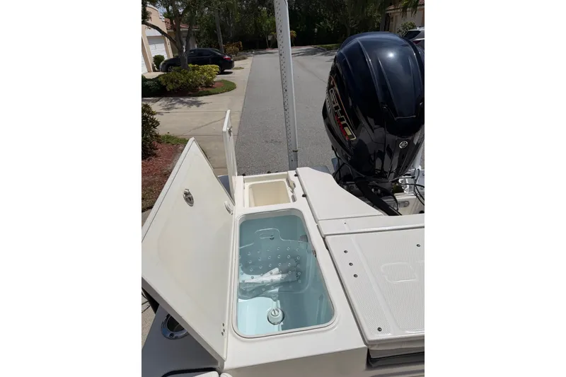 Slide: The Image of 2023 Robalo 226 Cayman boat with open storage compartment and powerful outboard motor. - 11