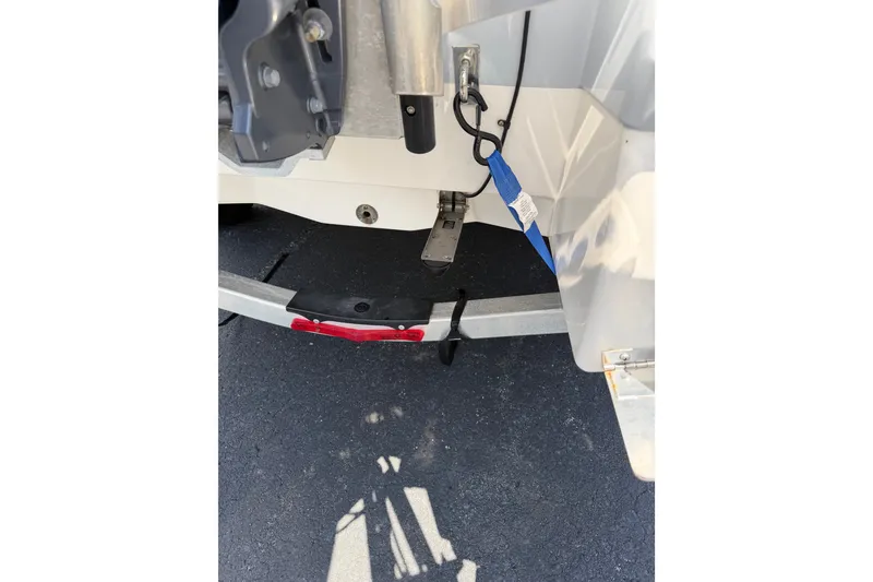 Slide: The Image of 2023 Robalo 226 Cayman boat trailer detail with safety straps and hitch components. - 19