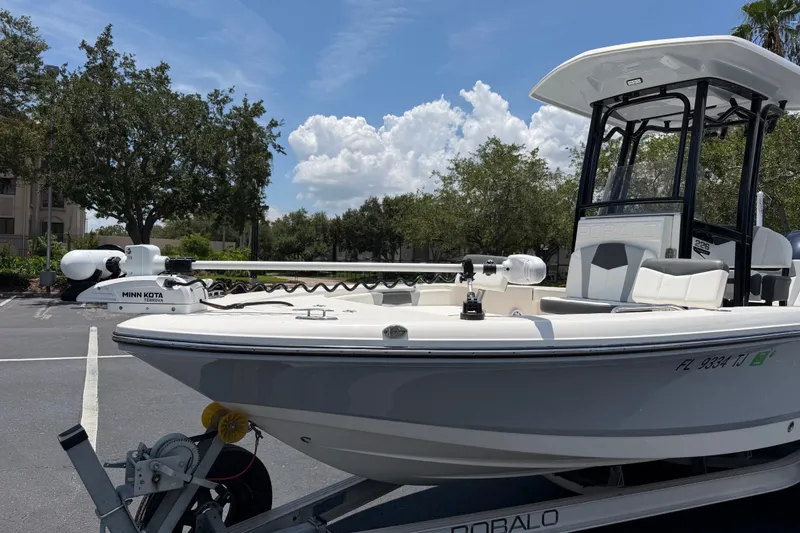 Slide: The Image of 2023 Robalo 226 Cayman boat on trailer, parked outdoors under a clear sky. - 2