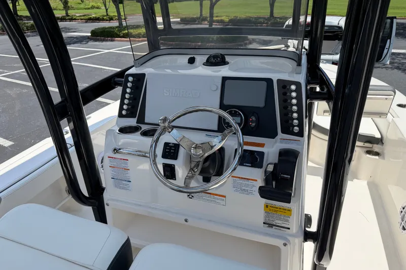 Slide: The Image of 2023 Robalo 226 Cayman boat console with steering wheel and navigation controls. - 6
