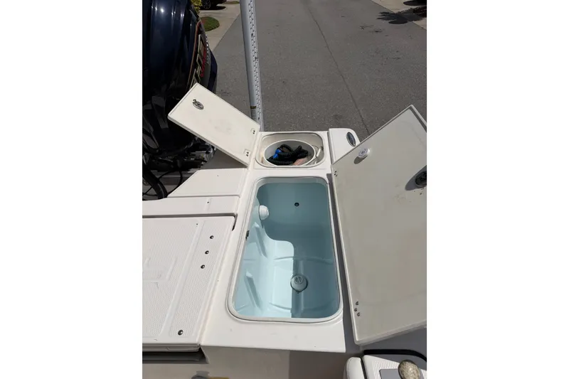 Slide: The Image of 2023 Robalo 226 Cayman boat with open storage compartments on deck. - 12