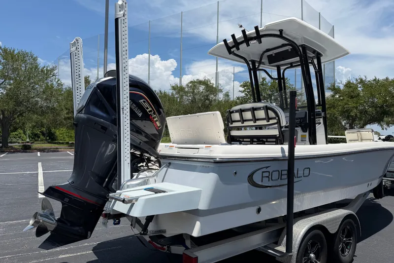 Slide: The Image of 2023 Robalo 226 Cayman boat on trailer with Yamaha engine, parked outdoors. - 5
