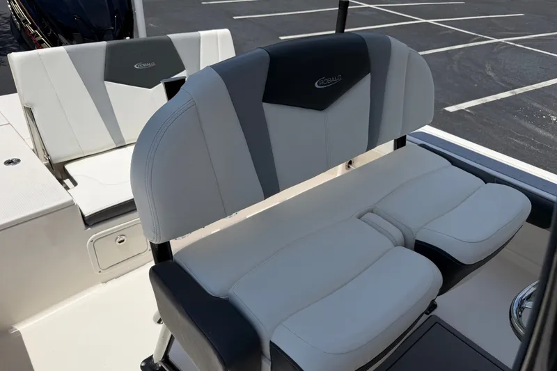 Slide: The Image of 2023 Robalo 226 Cayman boat seating with sleek, modern design in a parking lot. - 13