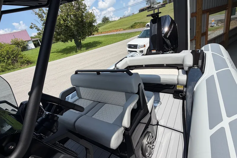 Slide: The Image of 2027 Brig Eagle 8 boat interior with modern seating and steering, parked near a road. - 23