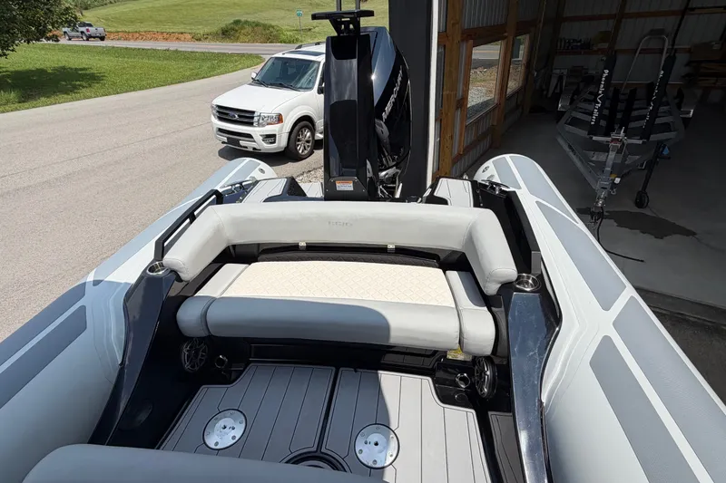 Slide: The Image of 2027 Brig Eagle 8 boat with sleek seating and powerful engine, parked near a garage. - 24