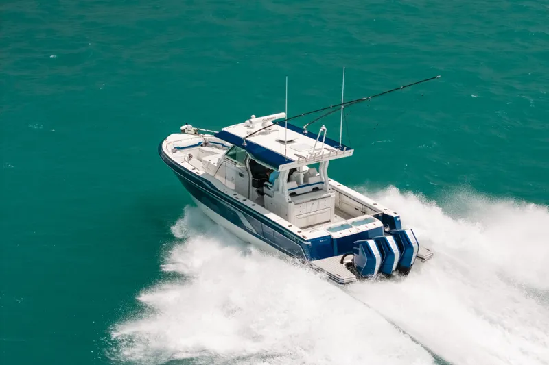 Slide: The Image of 2026 Formula 387 Center Console Fish boat cruising on turquoise waters. - 14