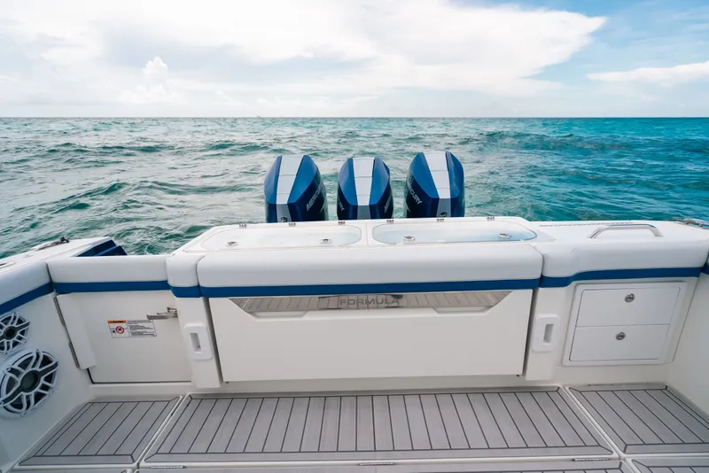 Slide: The Image of 2026 Formula 387 Center Console Fish boat with triple outboard motors on open sea. - 23
