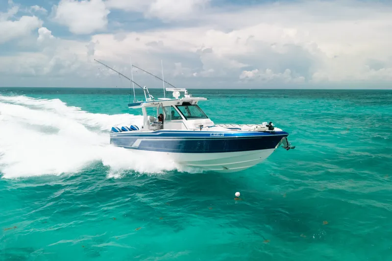 Slide: The Image of 2026 Formula 387 Center Console Fish boat cruising on turquoise ocean waters. - 9