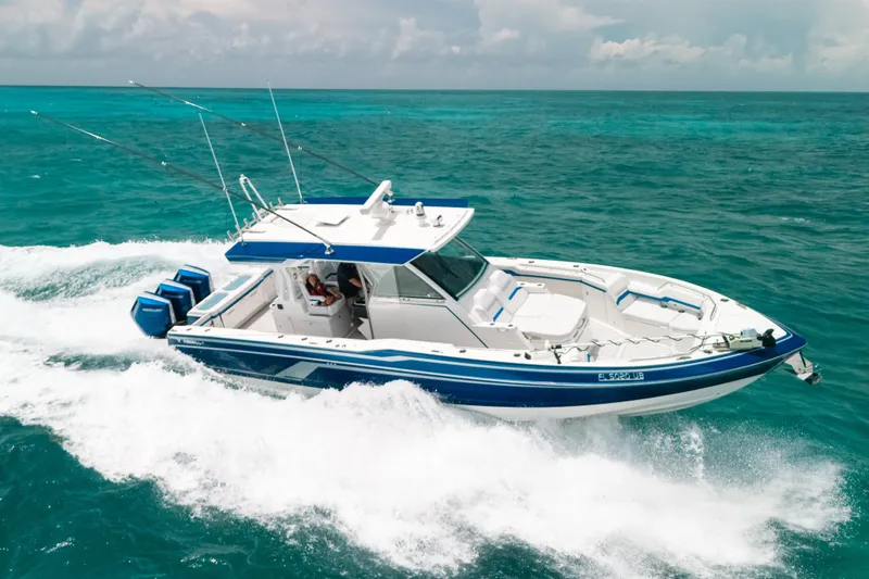 Slide: The Image of 2026 Formula 387 Center Console Fish boat cruising on turquoise ocean waters. - 0