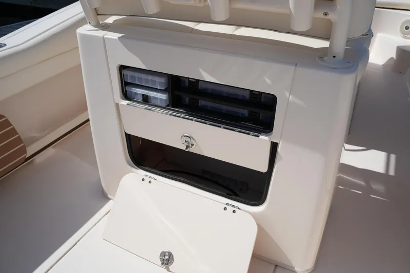 Slide: The Image of 2017 Grady-White Fisherman 236 boat storage compartment with tackle boxes and secure latch. - 16