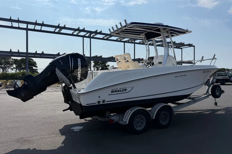Slide: The Image of 2014 Boston Whaler 220 Outrage boat on trailer, featuring Mercury outboard engine. - 4