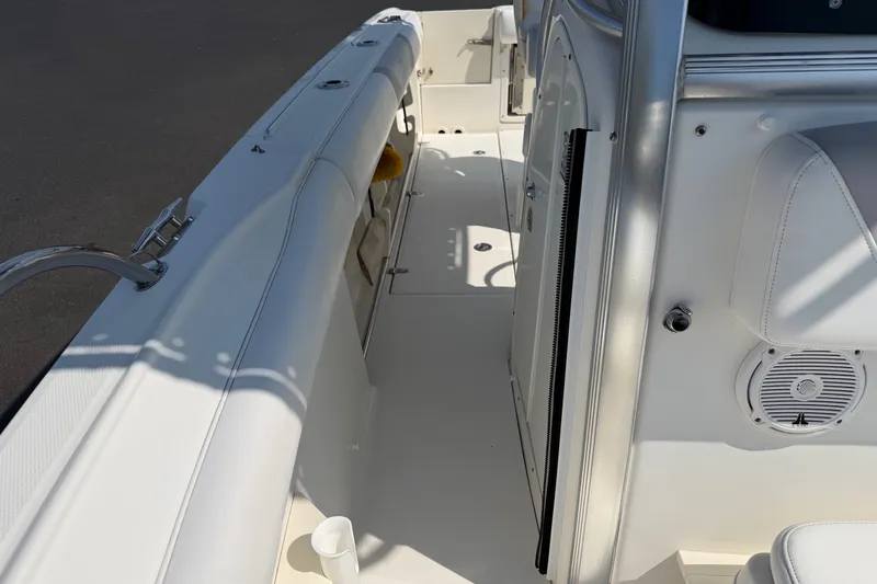 Slide: The Image of 2014 Boston Whaler 220 Outrage boat interior with white seating and deck details. - 8