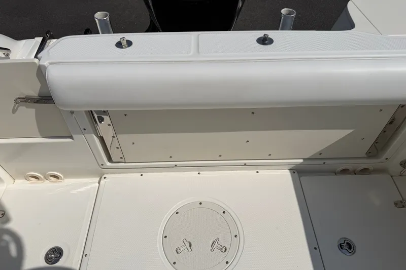 Slide: The Image of 2014 Boston Whaler 220 Outrage boat interior, featuring a clean, white deck and seating area. - 12