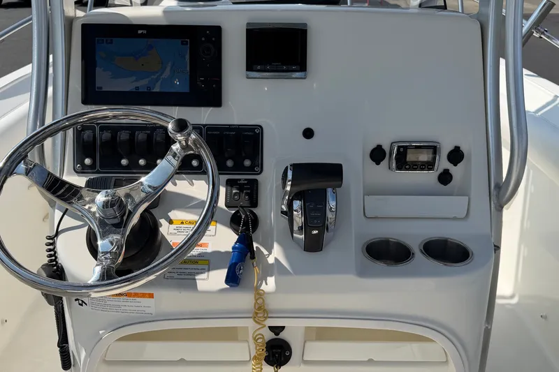 Slide: The Image of 2014 Boston Whaler 220 Outrage boat dashboard with steering wheel and navigation controls. - 14