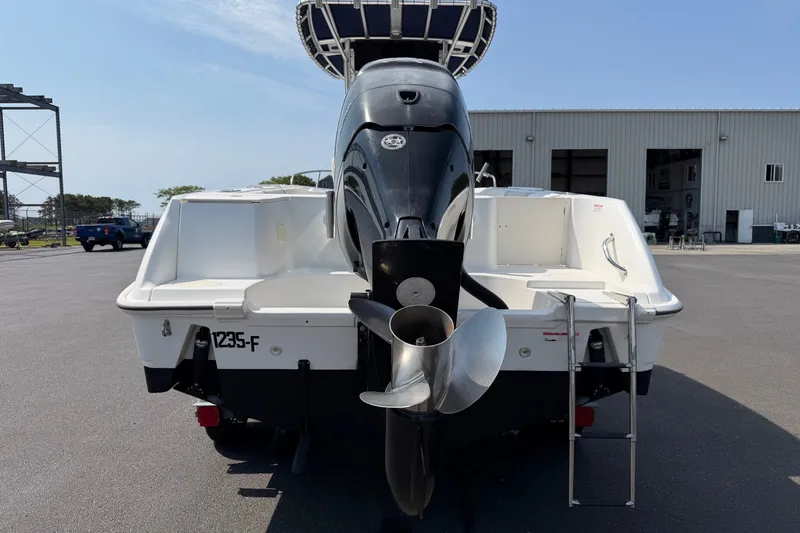 Slide: The Image of 2014 Boston Whaler 220 Outrage boat rear view with outboard motor and ladder. - 16