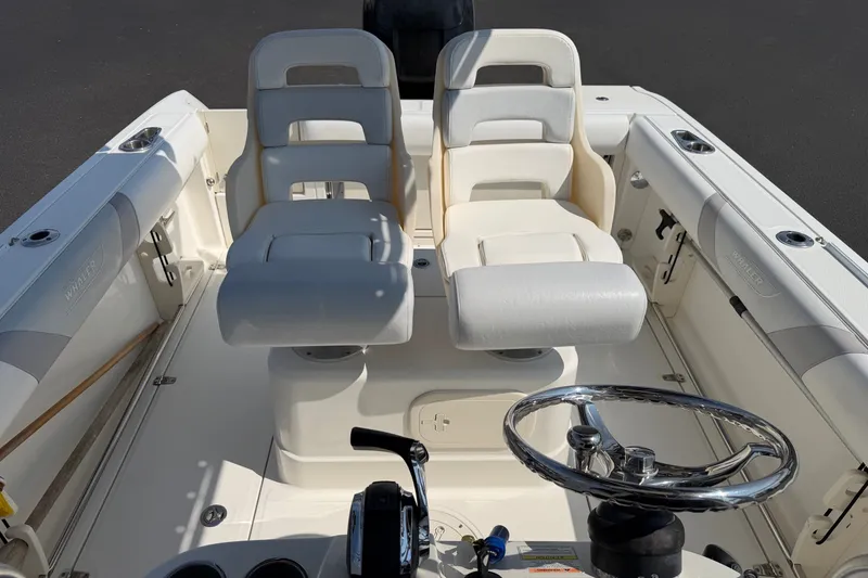 Slide: The Image of 2014 Boston Whaler 220 Outrage boat interior with dual seats and steering wheel. - 11