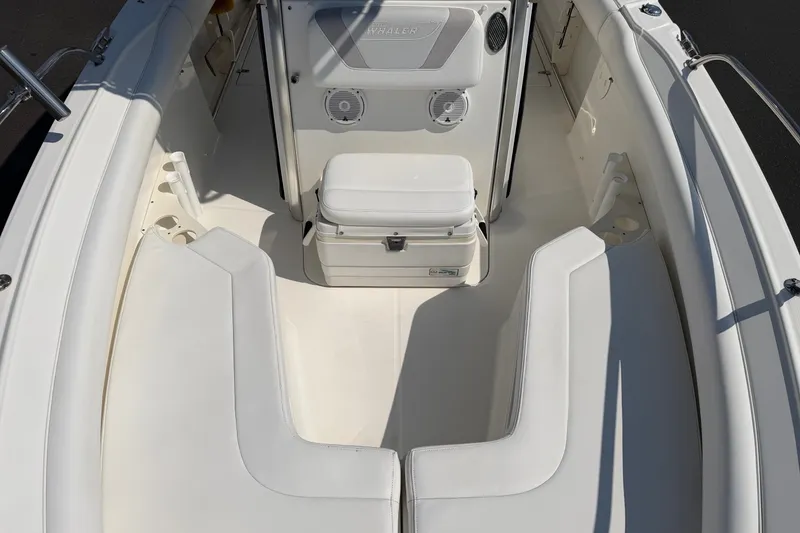 Slide: The Image of 2014 Boston Whaler 220 Outrage boat interior with cushioned seating and storage. - 6