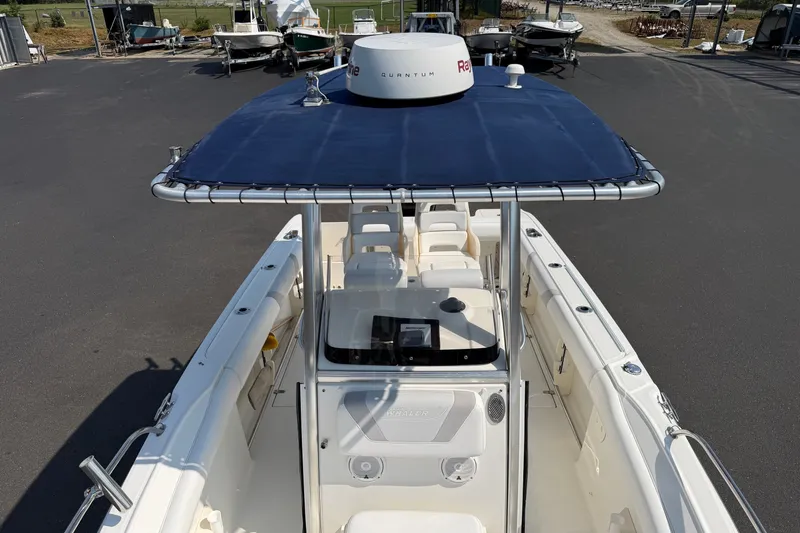 Slide: The Image of 2014 Boston Whaler 220 Outrage boat with blue canopy, parked in a marina. - 7