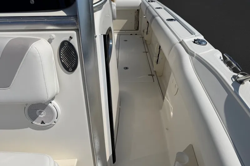 Slide: The Image of 2014 Boston Whaler 220 Outrage interior with white seating and speaker detail. - 9