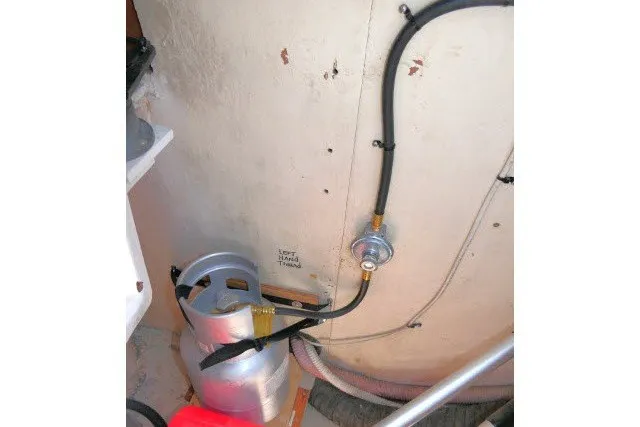 Slide: The Image of Propane tank installation in a 2001 Hunter 420 boat, featuring secure hose connections. - 77