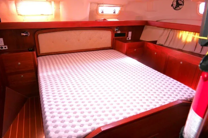 Slide: The Image of Cozy cabin interior of 2001 Hunter 420 sailboat with wooden furnishings and a comfortable bed. - 25