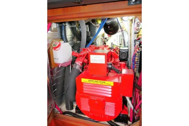 Slide: The Image of Engine compartment of a 2001 Hunter 420 sailboat, featuring a red marine engine. - 89