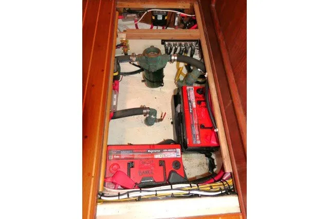 Slide: The Image of Battery compartment of a 2001 Hunter 420 sailboat, featuring wiring and plumbing components. - 78