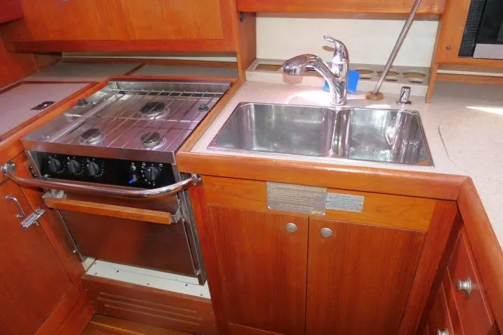 Slide: The Image of Compact kitchen area in a 2001 Hunter 420 sailboat with stove and sink. - 16