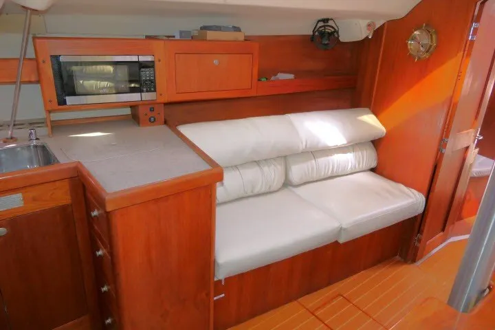 Slide: The Image of Interior of a 2001 Hunter 420 yacht with wooden cabinetry and white seating. - 6