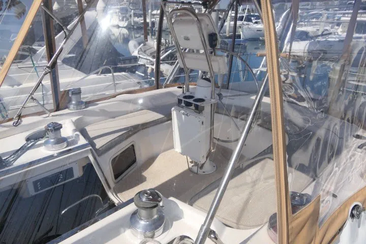 Slide: The Image of 2001 Hunter 420 sailboat cockpit with clear canopy and winches in marina setting. - 49