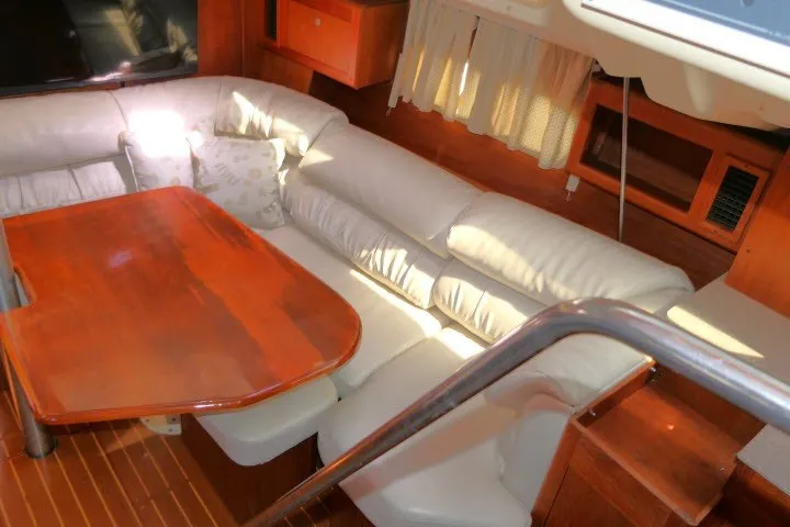Slide: The Image of Interior of 2001 Hunter 420 yacht with white leather seating and wooden table. - 8
