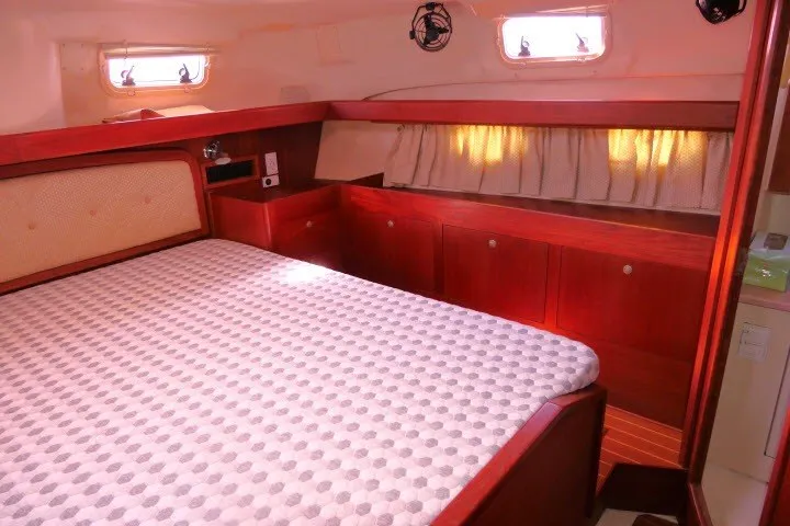 Slide: The Image of Interior of a 2001 Hunter 420 yacht cabin with a cozy bed and wooden cabinetry. - 28