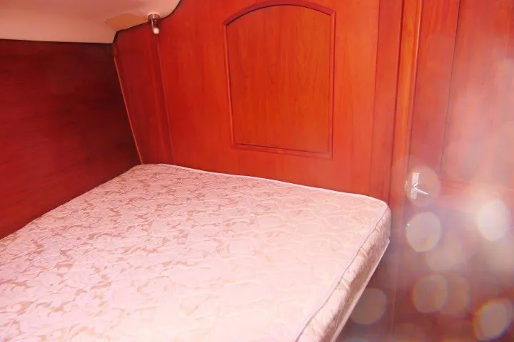 Slide: The Image of Interior cabin of 2001 Hunter 420 sailboat with wooden paneling and mattress. - 19