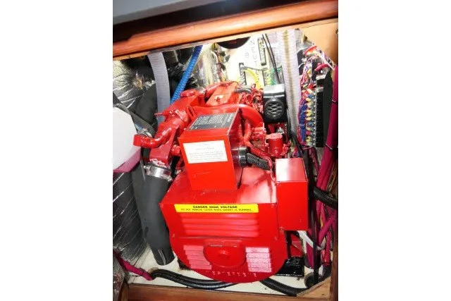 Slide: The Image of Red engine inside a 2001 Hunter 420 sailboat, surrounded by wiring and components. - 90