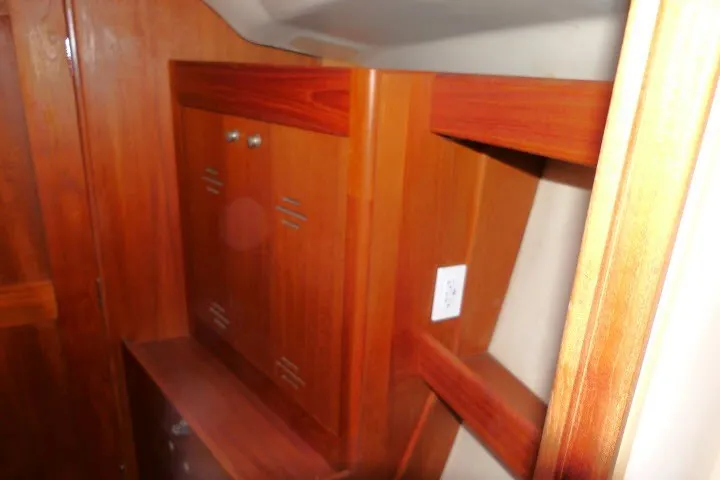 Slide: The Image of Interior wooden cabinetry of a 2001 Hunter 420 sailboat, showcasing storage space. - 20
