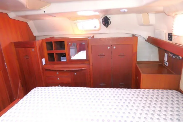 Slide: The Image of Interior of 2001 Hunter 420 yacht cabin with wooden cabinetry and bed. - 26
