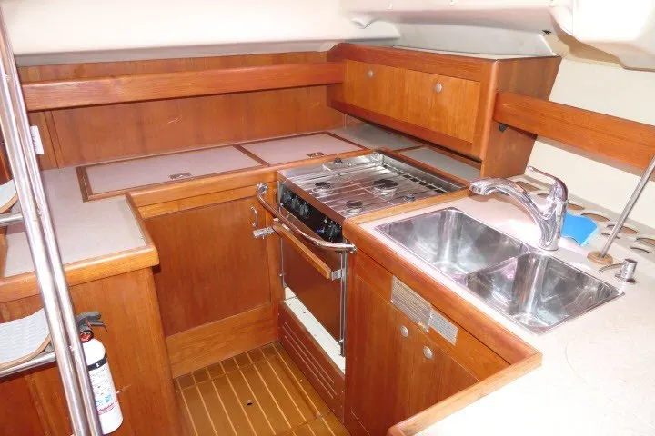 Slide: The Image of Interior of 2001 Hunter 420 yacht kitchen with wooden cabinetry and stainless steel sink. - 12