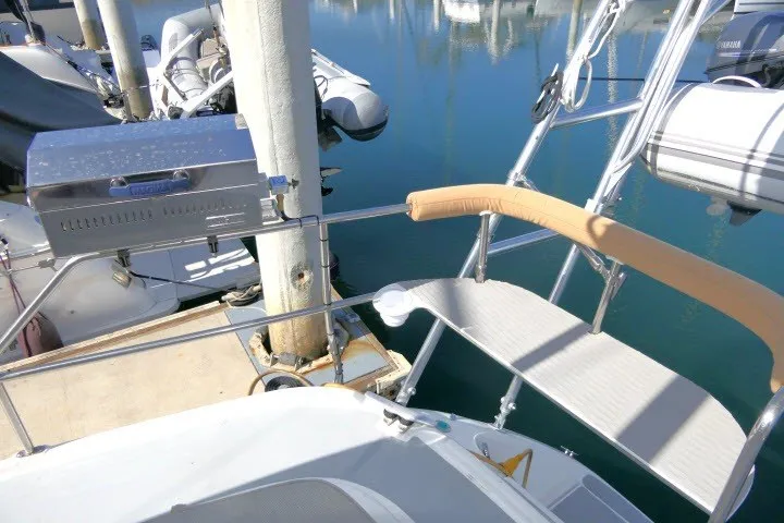 Slide: The Image of Hunter 420 sailboat docked, featuring a stainless steel grill and cushioned seating, 2001 model. - 57