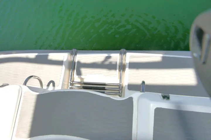 Slide: The Image of Hunter 420 sailboat deck with stainless steel ladder, 2001 model, above green water. - 60